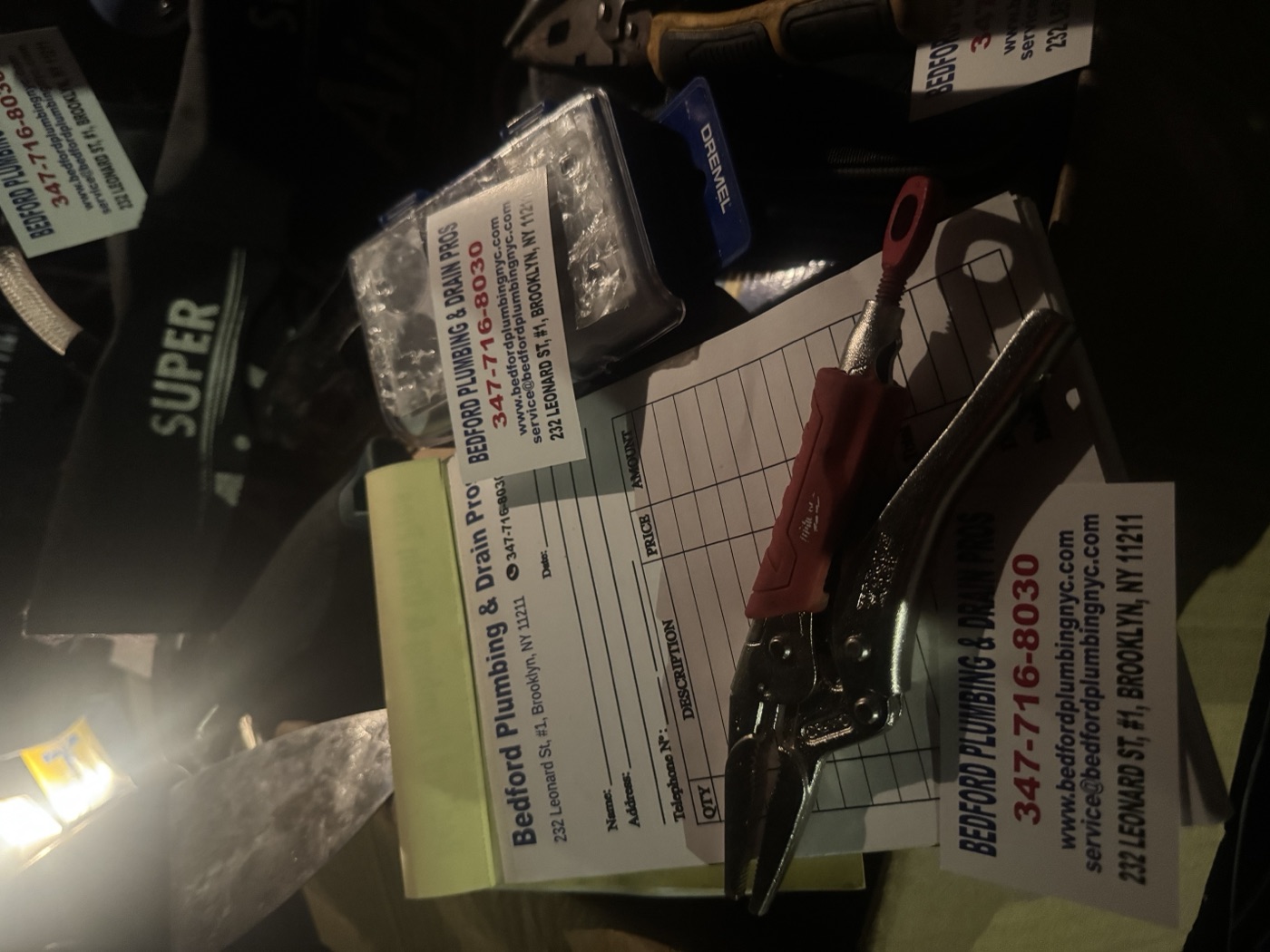 Bedford Plumbing & Drain Pros invoice pad and tools on a job